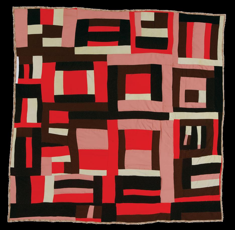 A quilt with a geometric pattern. Strips of pink, red, white, black, and brown are arranged either horizontally or vertically, resulting in a grid-like effect.